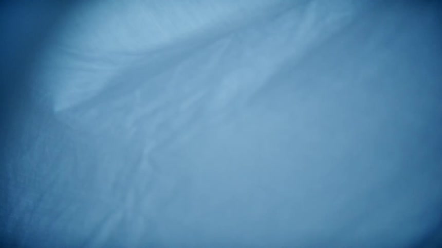 A purple sheet of thin fabric blows gently in the breeze