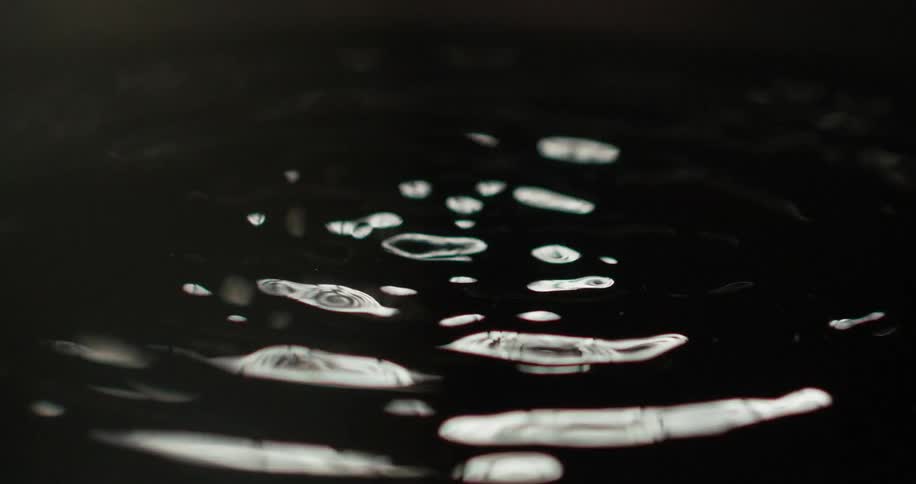 Brown liquid being vibrated and creating ripples