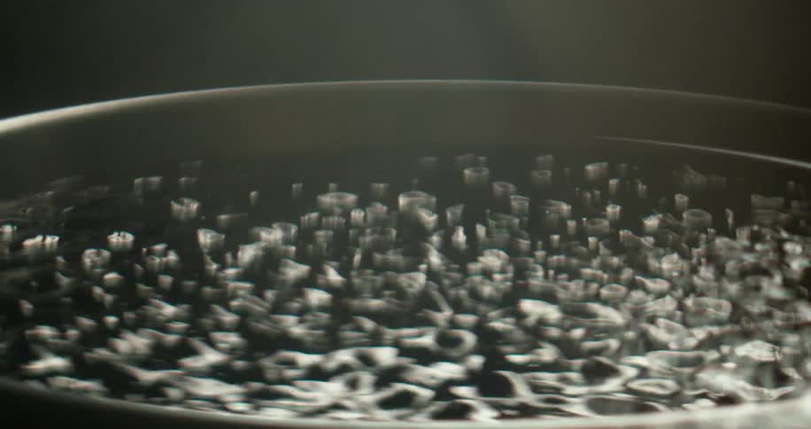 Water in a container moving and jumping to vibrations