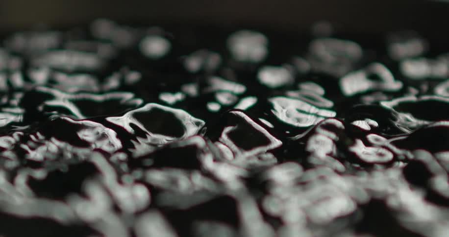 Close up of dark liquid moving and rippling