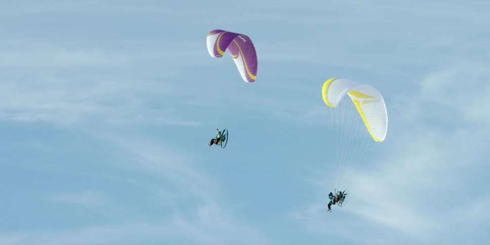 People are parasailing in a blue sky