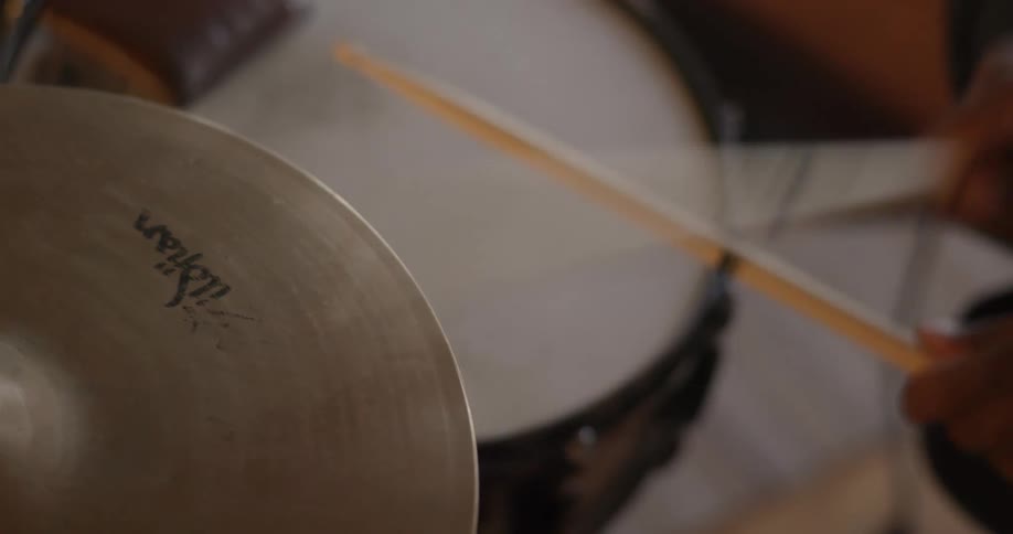 Male drummer plays the drums by hitting it with sticks