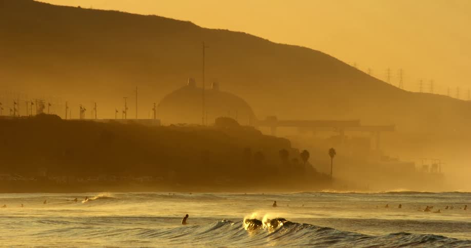 The sun is setting above the ocean coast