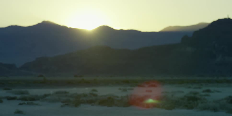 The sun shines over a mountain ridge