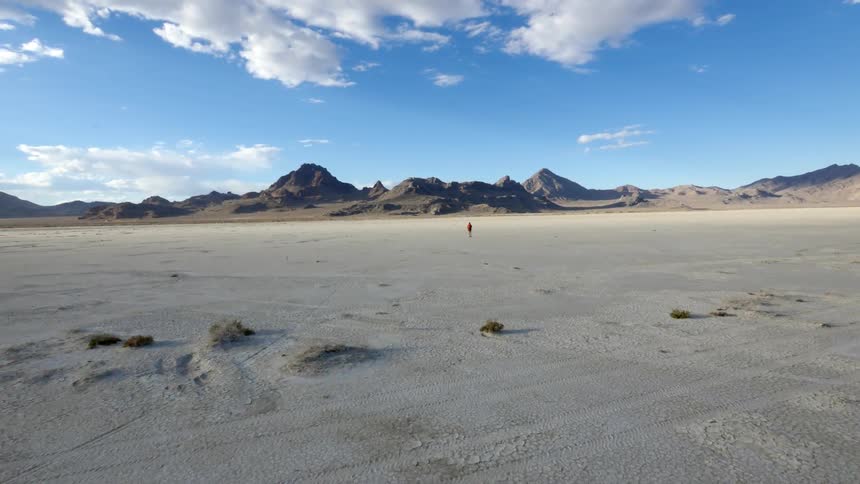 A person walks across a flat land