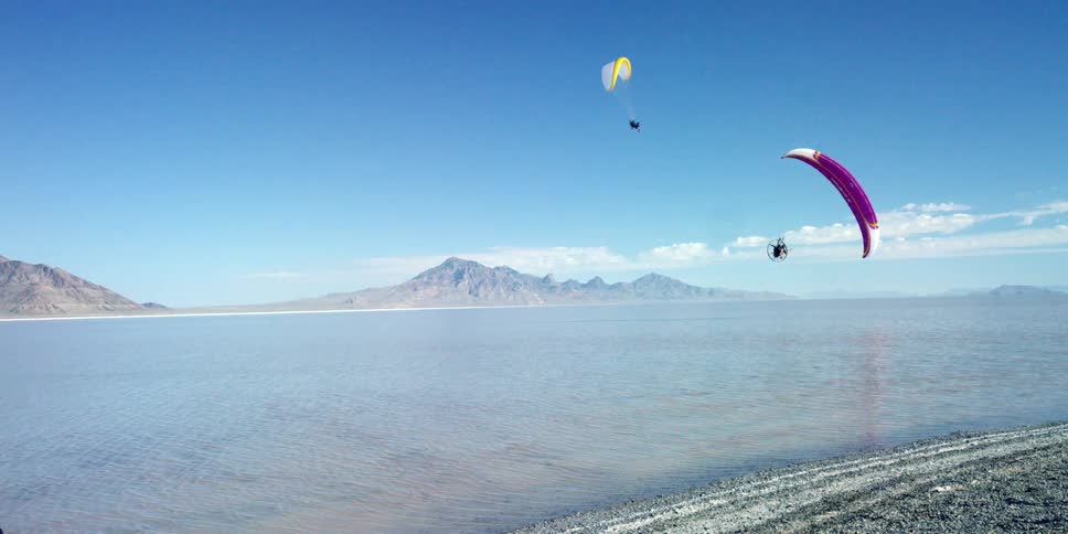 People are parasailing in a blue sky