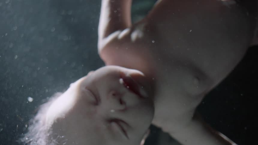 Babys hair waves as unborn child floats in fluid