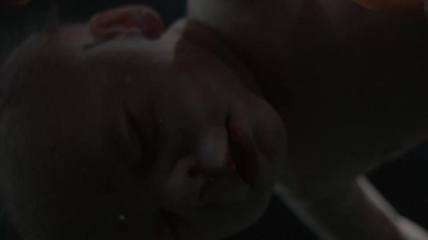A baby is floating with light and then darkness