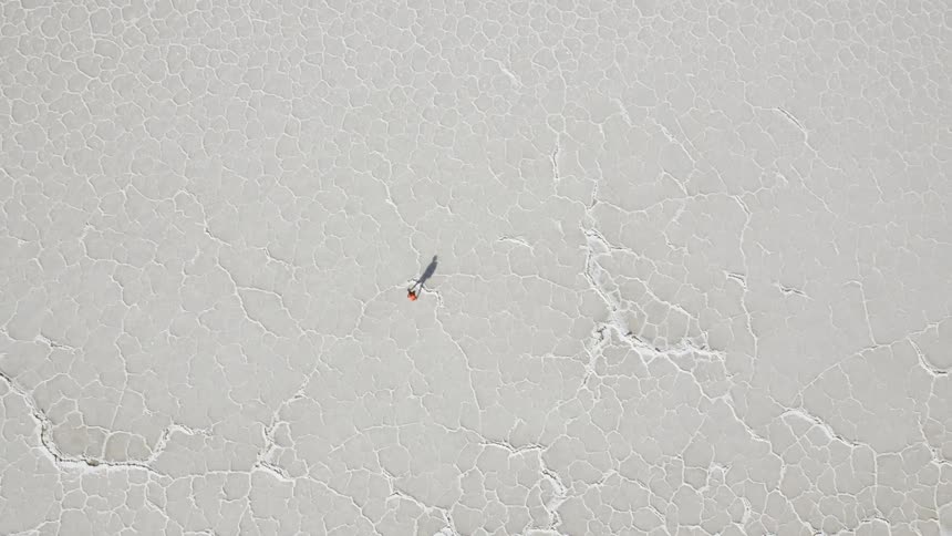 Person hiking across a desolate salt lake