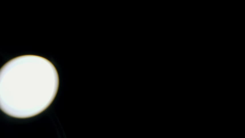 A bright light from a lamp glows in a dark room