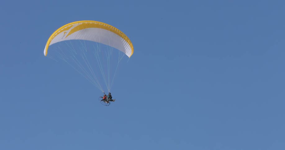 People parasailing in a blue sky
