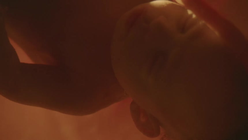 Close up of unborn babys face and umbilical cord in the womb