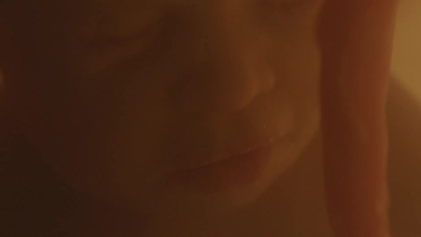 Close up of an unborn fetus face and umbilical cord floating inside the womb