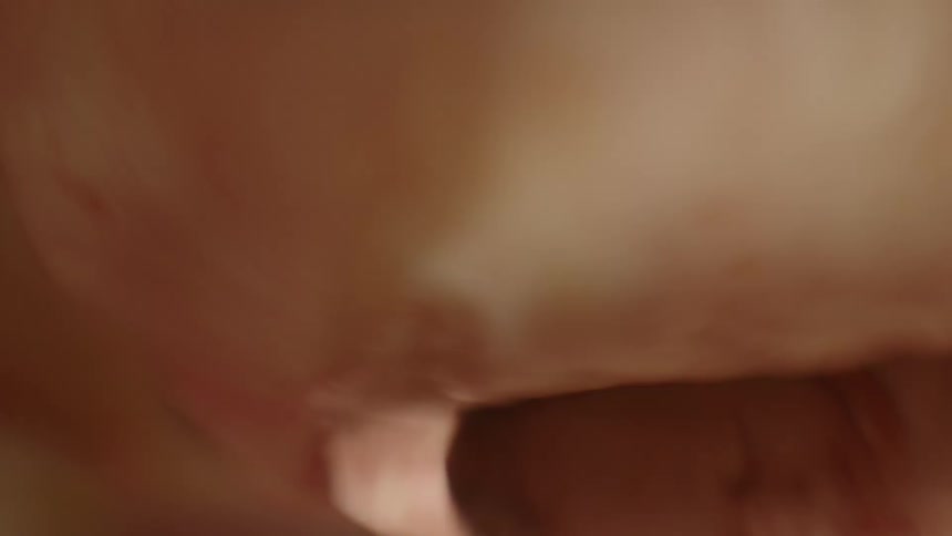A baby is nestled in layers of white with white light