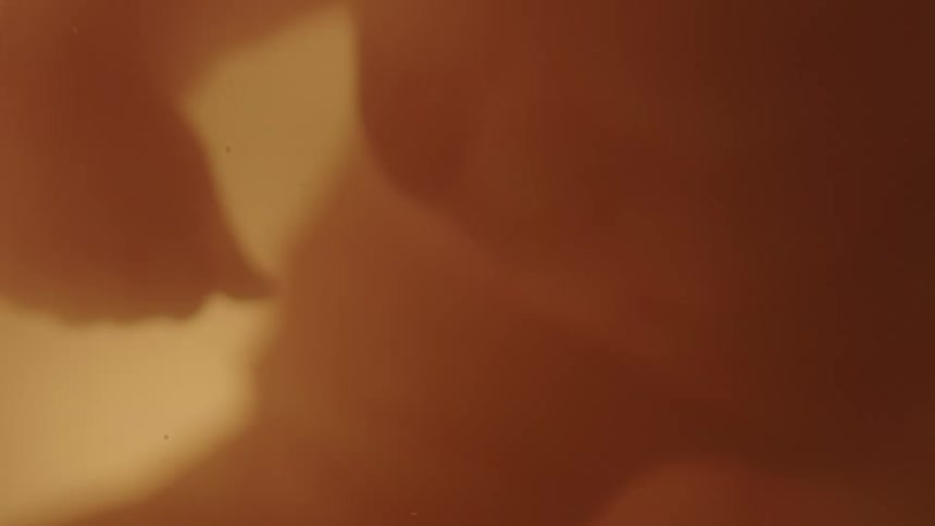 Unborn human baby floating in the liquid inside the womb