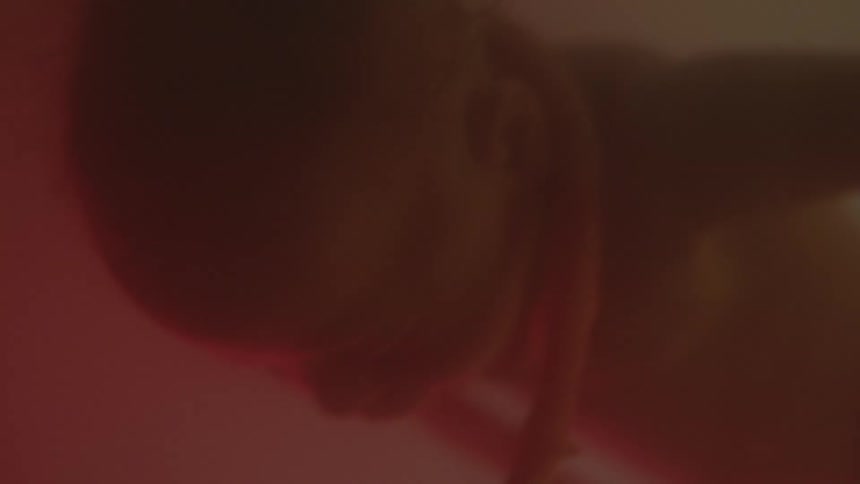 A fetus floating in amniotic fluid has its umbilical cord wrapping around its neck