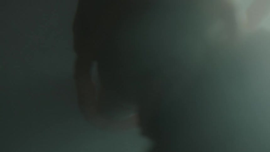 Unborn baby turns and floats in fluid lit by light