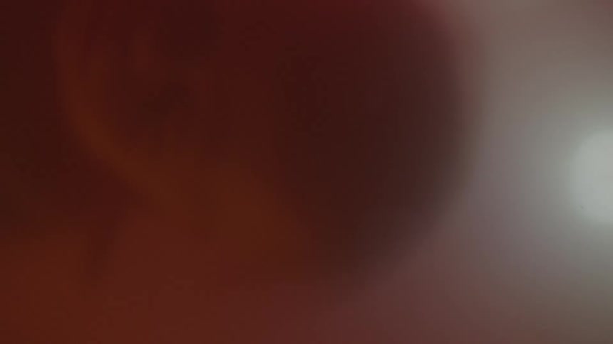 A persons shadow is seen in an alternating bright white and dark red light