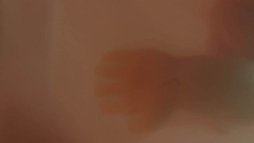 The hand of a developed fetus is outstretched while it rest within the womb