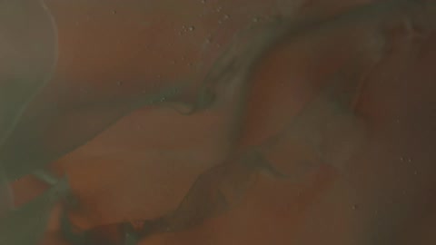 A thick liquid appears to be swirling as the illumination around it changes