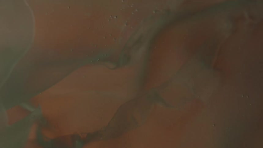 A thick liquid appears to be swirling as the illumination around it changes