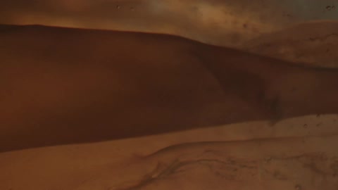 A gauzy object moves in liquid as light flashes in and out