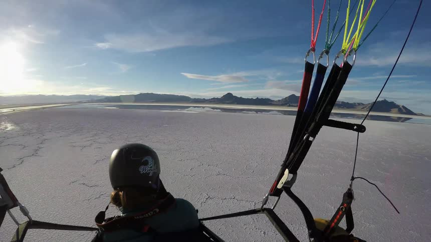 People gliding through the air on paramotors
