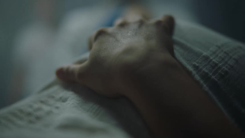 A woman holds her hand to her pregnant stomach while she breathes heavily