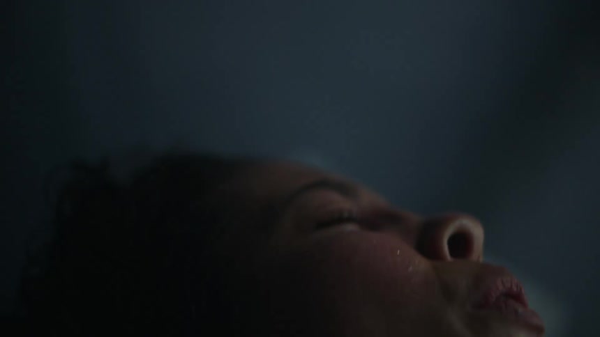 Woman lies on back grimacing and breathing through labor