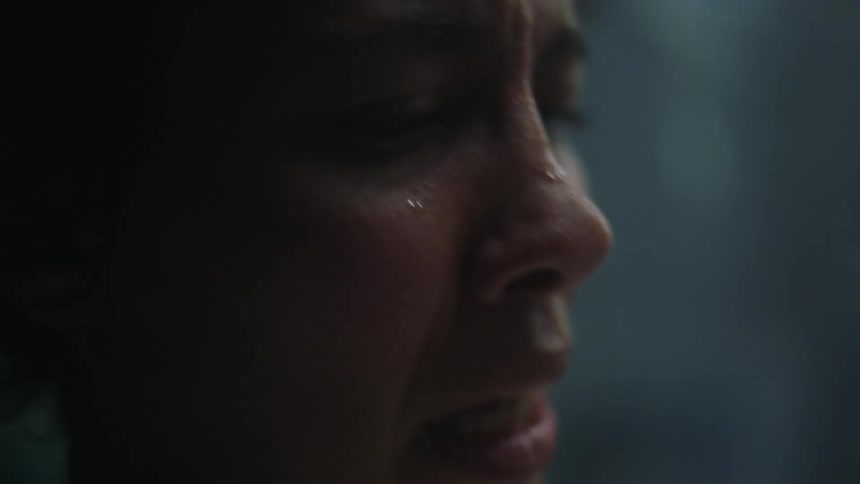 A woman lays back as she is in a great deal of pain and anguish