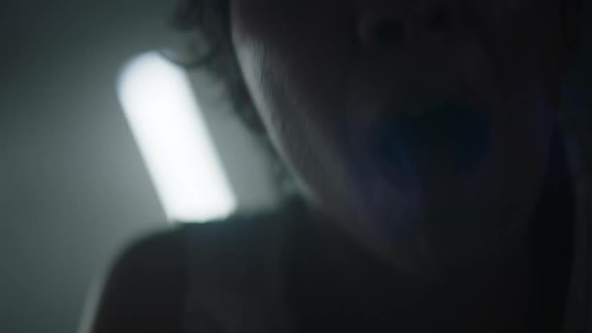 Close up of the silhouette of a screaming woman face in a dimly lit room