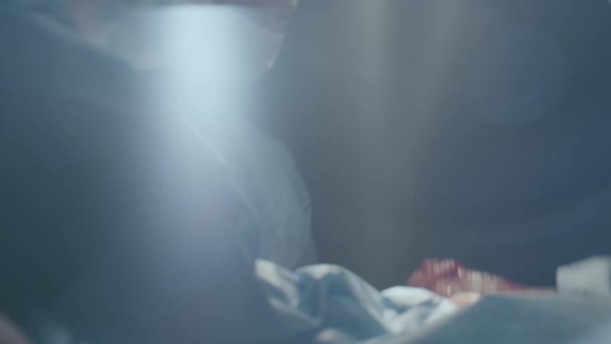 Medical professionals are all gathered around to tend to a newborn baby