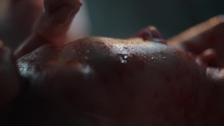 Newborn human baby covered in blood after birth breathing on a hospital
