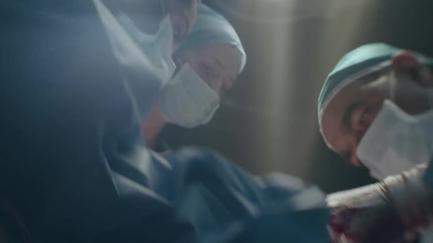 A team of medical professionals quickly tend to a newborn baby