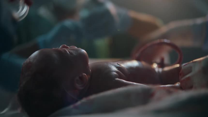 Three nurses try to revive unresponsive newborn in a hospital with a light behind them
