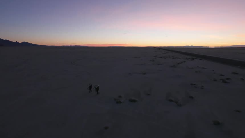 Aerial view of two people hiking at sunset