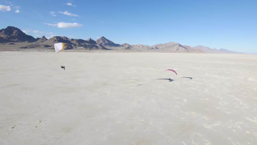 Two people are taking off into air parasailing