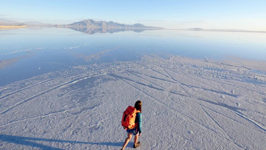 Woman hiking across a desolate salt lake