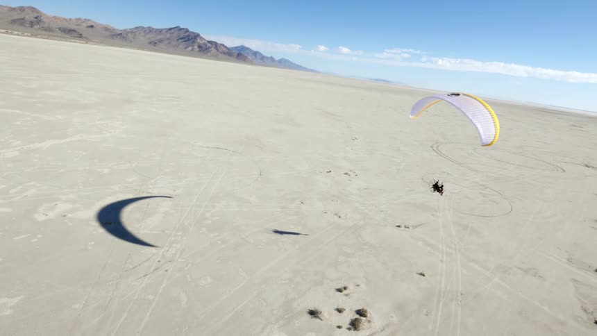 People are parasailing over a desert area
