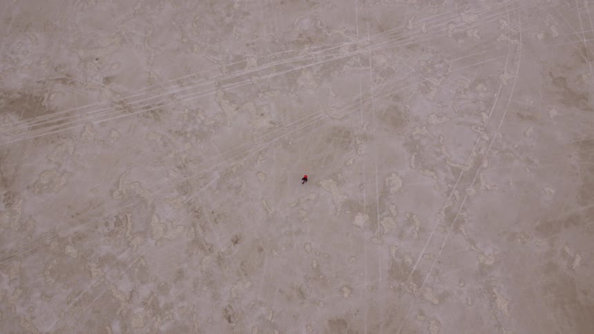 Aerial view of a person walking over a desert