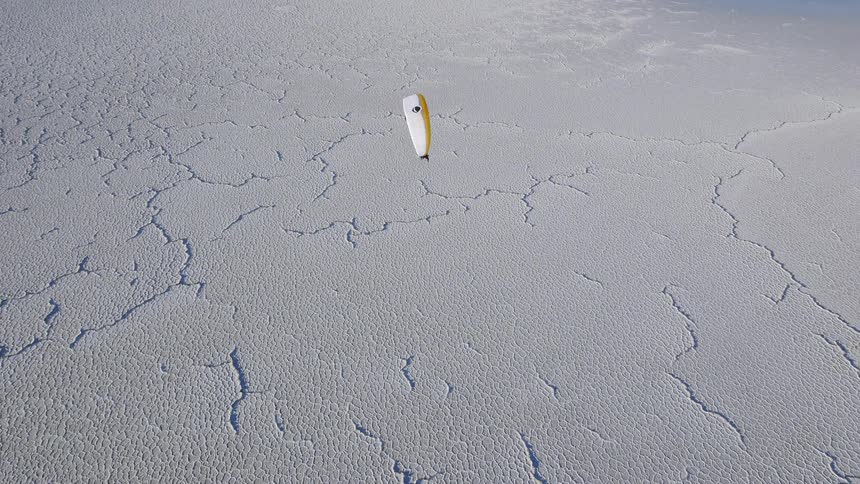 A person is parasailing over a desert area