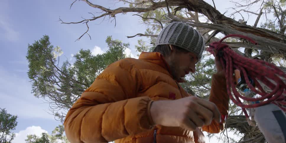 Man tightens a rolled up length of rope