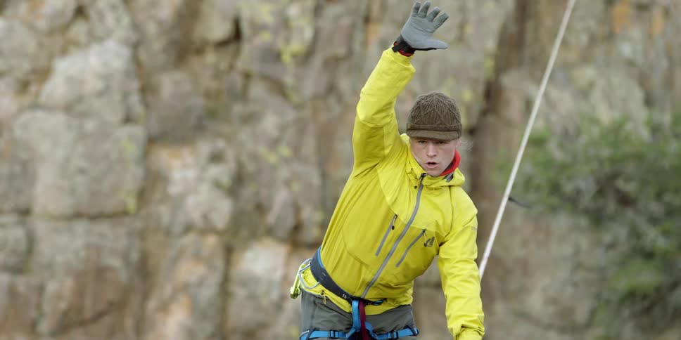 Man balancing on a tightrope over a canyon