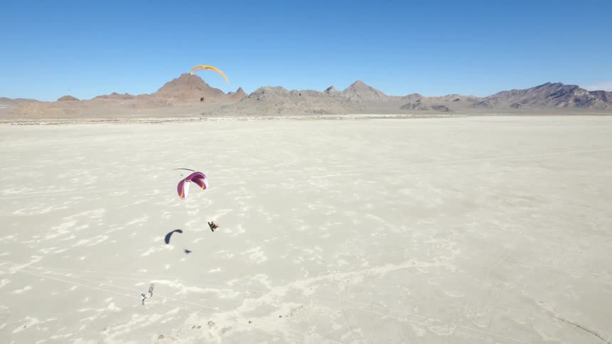 People parasailing in the desert