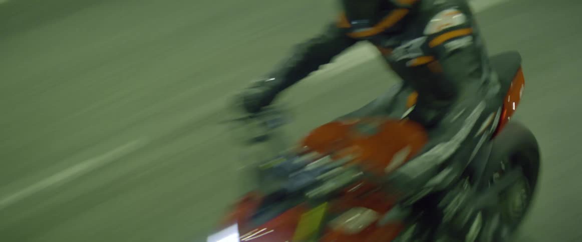 A person rides a motorcycle on a road at night