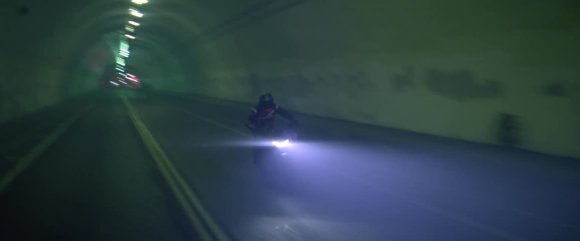 A person driving a motorcycle through a tunnel