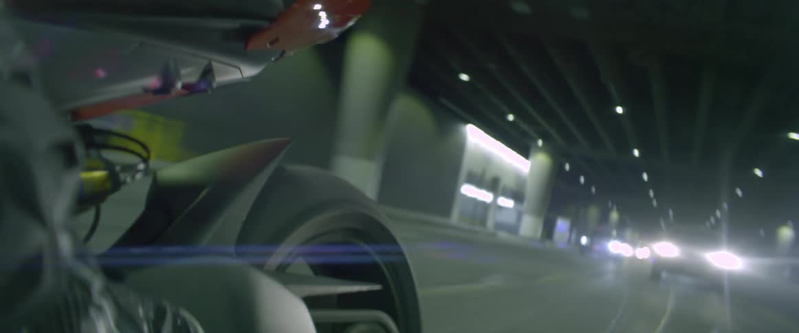 A motorcycle being driven in front of cars on a city street