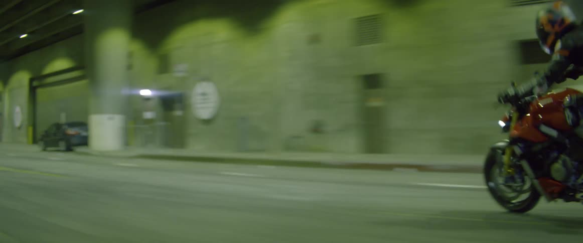 Motorcycle driving in traffic at full speed on a tunnel in the city at night