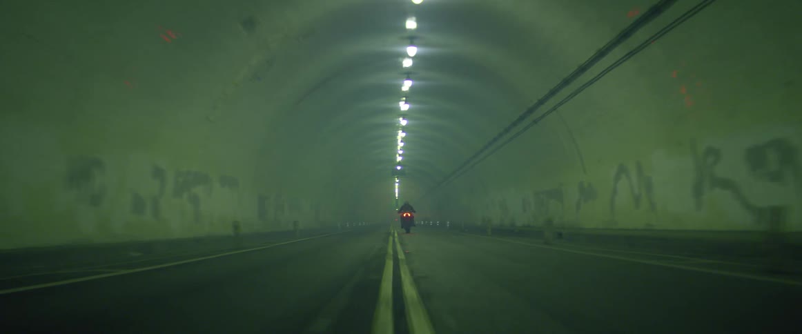 A person driving a motorcycle through a tunnel