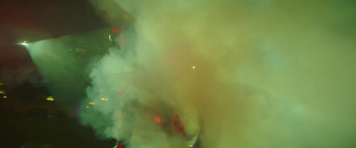 A motorcycle rider is surrounded by tire smoke
